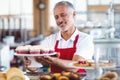 Happy barista holding a plate of cupcakes