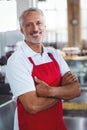 Happy barista smiling at camera with arms crossed