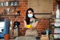 Happy barista welcoming guests at own cafeteria, offering cup of hot beverage, return to work after covid-19 pandemic Royalty Free Stock Photo