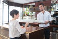 happy barman serving female customer