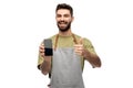 Happy barman showing smartphone and thumbs up