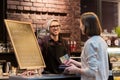 Happy barman and woman paying money at cafe