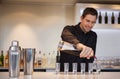 Happy bartender pouring cocktail into shot glasses Royalty Free Stock Photo