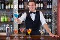 Happy bartender serving a blue martini