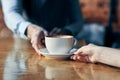 happy bartender serving a cup of coffee to a patient in a cafe drink brick wall interior