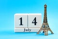 Happy Bastille day and French national day concept with a block calendar set on July 14, a miniature of the Eiffel Tower isolated Royalty Free Stock Photo
