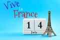 Happy Bastille day and French national day concept with a block calendar set on July 14, a miniature of the Eiffel Tower isolated Royalty Free Stock Photo