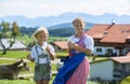 Happy Bavarian children drink milk on the meadow with cow . Alps Royalty Free Stock Photo