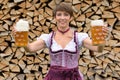 Happy Bavarian woman holding two tankards of beer