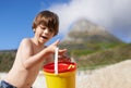 Happy, beach and child with bucket and toys on summer holiday, vacation and relax by ocean. Childhood, building sand Royalty Free Stock Photo