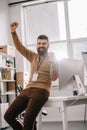 Happy bearded adult businessman wearing blank security tag and holding arms up