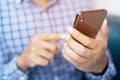 Happy bearded African businessman using phone while sitting on sofa Royalty Free Stock Photo