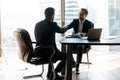 Happy bearded businessman in suit shaking hands with job seeker.