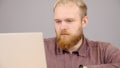 Happy bearded caucasian business man working on laptop from home office. Royalty Free Stock Photo