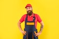 happy bearded deliveryman in work clothes on yellow background