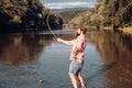 Happy bearded fisher in water. Fishing on the lake at the morning. Gone fishing. Fisherman with rod and fish. Set up rod Royalty Free Stock Photo