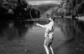 Happy bearded fisher in water. Fishing on the lake at the morning. Gone fishing. Fisherman with rod and fish. Set up rod Royalty Free Stock Photo