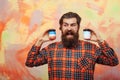 Happy bearded man holding two cosmetic jars