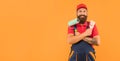 happy bearded man housepainter in work clothes hold paint roller and brush on yellow background