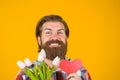 Happy bearded man with paper heart and flowers. Valentines Day presents. Advertising. Royalty Free Stock Photo