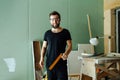 Handsome smiling bearded man standing with corner ruler in rennovating apartment Royalty Free Stock Photo