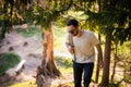 Happy bearded man traveler with backpack walking in forest. Tourism, travel, adventure, hike concept - smiling young man