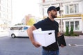 Happy bearded postman goes to client's home