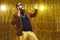 Happy bearded showman singing, dancing and having fun on stage with golden background Royalty Free Stock Photo