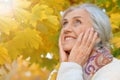Happy beautifil elderly woman posing in autumn park Royalty Free Stock Photo