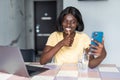 Happy beautiful African American woman taking selfie on mobile phone camera, showing victory sign. Emotional blogger streaming Royalty Free Stock Photo