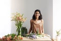 Happy beautiful african female florist smiling looking at camera at workplace in flower shop. Copy space. Royalty Free Stock Photo