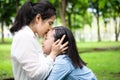 Happy beautiful asian adult woman and cute child girl with hugging,kissing and smiling in summer,love of mother with her little Royalty Free Stock Photo