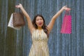 Happy and beautiful Asian Korean woman walking on the street posing on background smiling cheerful carrying shopping bags Royalty Free Stock Photo