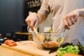 Happy beautiful asian man prepare salad food in the kitchen. Young asian male cooking healthy food while staying at home. Royalty Free Stock Photo