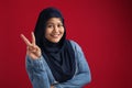 Happy beautiful Asian muslim woman posing in front of camera and smiling, showing peace victory hand sign Royalty Free Stock Photo