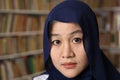 Happy beautiful Asian muslim woman wearing hijab smiling to camera, female student in library Royalty Free Stock Photo