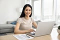 Happy beautiful Asian student girl studying at laptop at home Royalty Free Stock Photo