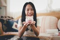 Happy beautiful asian young woman with pink piggy bank on hands and coins on table, Finance or Savings concept. Royalty Free Stock Photo