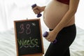 Close up Happy Beautiful Attractive Pregnant Asian Woman sitting on bed smile and holding her big belly Royalty Free Stock Photo