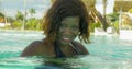 Happy and beautiful black African American woman in bikini having fun at tropical beach resort swimming pool relaxed and playful Royalty Free Stock Photo