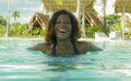 Happy and beautiful black African American woman in bikini having fun at tropical beach resort swimming pool relaxed and playful Royalty Free Stock Photo