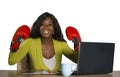 Happy beautiful black afro American woman in boxing gloves smiling cheerful working at office computer desk posing as successful e Royalty Free Stock Photo