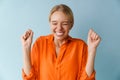 Happy beautiful blonde girl smiling and making winner gesture Royalty Free Stock Photo