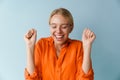 Happy beautiful blonde girl smiling and making winner gesture Royalty Free Stock Photo