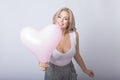 Happy beautiful blonde woman holding pink heart balloon Royalty Free Stock Photo