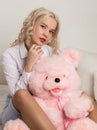 Happy beautiful blonde woman hugging a teddy bear. Concept of holiday or birthday Royalty Free Stock Photo