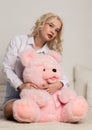 Happy beautiful blonde woman hugging a teddy bear. Concept of holiday or birthday Royalty Free Stock Photo