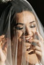 Happy beautiful bride under veil closeup. Beautiful bride shows makeup Royalty Free Stock Photo