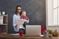 Young mother working and spending time with baby