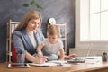 Young mother holding baby while writing notes